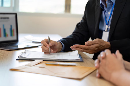Insurance Consultation. Businessman discussing policy details with client in office.