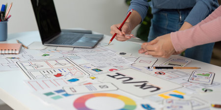 Creative UX and UI Design Process. Team members sketching and refining wireframes in a collaborative...