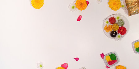 Diwali sweets and flowers scattered on a clean white surfaceの写真素材