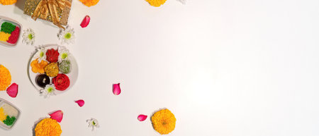 Minimalist Diwali setup with sweets and flowers on a white backgroundの写真素材