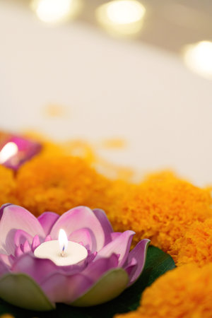 Lotus Candle Focus. A close-up of a lotus candle surrounded by marigold flowers for Diwali.の写真素材