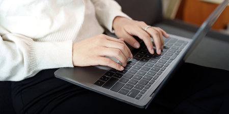 Productivity. Young woman typing on a laptop at home.