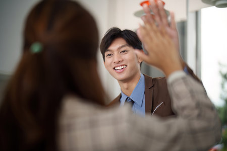 Positive Interaction. Colleague sharing a high-five in a professional setting.