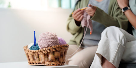 Knitting Essentials: Colorful yarn basket and hands at work in a cozy space