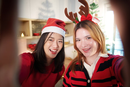 Joyful Christmas Selfie with Friends in Festive Outfitsの写真素材