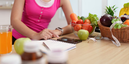 Healthy Lifestyle. Woman planning nutritious meals with fresh vegetables and fruits.の写真素材