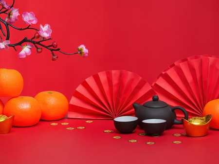 Chinese New Year Tea Ceremony. Teapot and cups with oranges on a vibrant red background.の写真素材