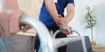 Caregiver assisting elderly patient with walker for mobilityの写真素材