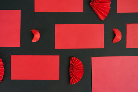 Chinese New Year decorations with red envelopes and fans on black backgroundの写真素材