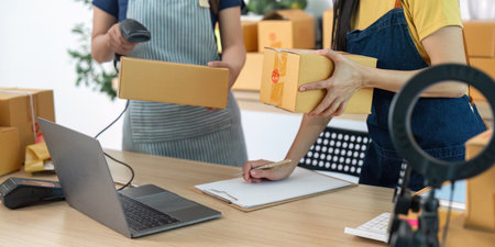 Teamwork in E-commerce. Two women collaborating in a packaging and shipping workspace.