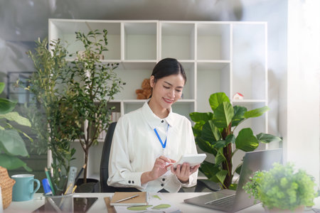 Businesswoman using tablet for work in modern officeの写真素材