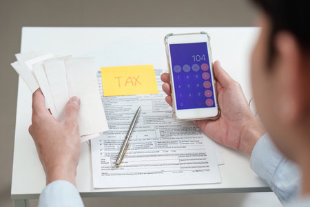 Tax Calculation. Individual using smartphone calculator for tax preparation.の写真素材