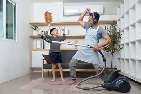 Father and son enjoying cleaning with music, promoting teamwork