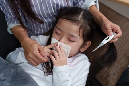 Mother Caring for Sick Daughter with Fever