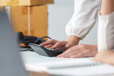 Office Collaboration. Close-up of hands using a telephone in a business setting.