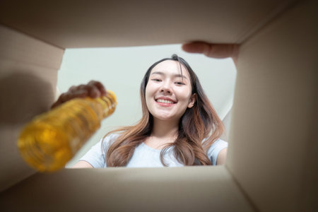 Food Donation. A woman smiling while looking into a donation box.