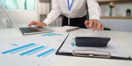 Accountant analyzing financial data with a calculator and charts