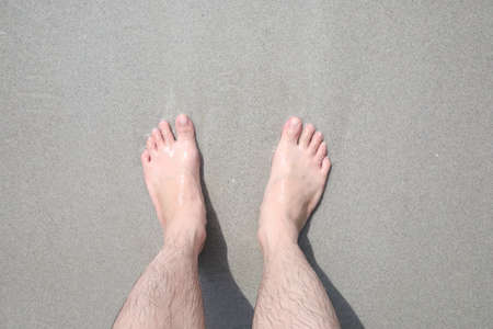 Close up of a man's feet on the sand of a beachの写真素材