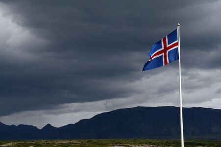 Iceland flag on the bacground of a stromy sky over the Thingvellir National Parkの写真素材
