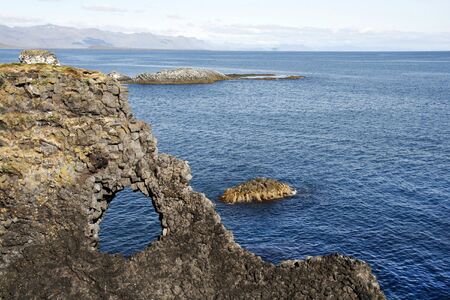 Beautiful cliffs and basalt rocks in Arnarstrapi - picturesque town on Snaefellsnes penisula in western Iceland. View on Atlantic Ocean.の写真素材