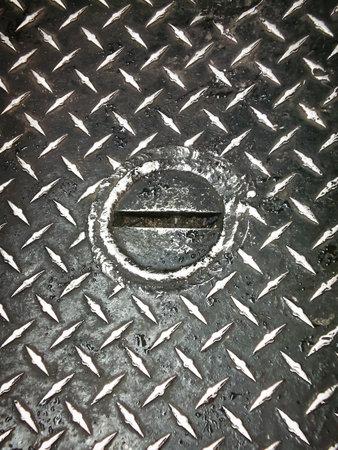 Rusty metal plate with hole in it, closeup of photoの写真素材