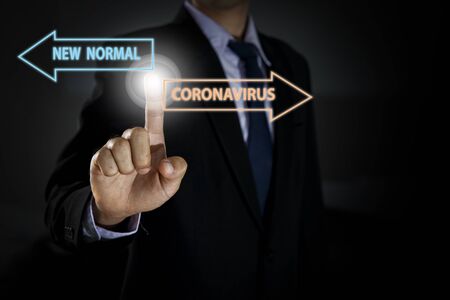 Businessman touching button The New normal and coronavirus in arrow direction. New normal after Covid-19 pandemic. Coronavirus outbreak concept.の写真素材