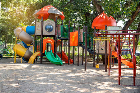 A children's playground, a slider located on the sand.