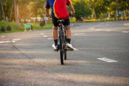 Healthy  athlete man exercising cycling in the park. A man riding a mountain bike in a summer day.