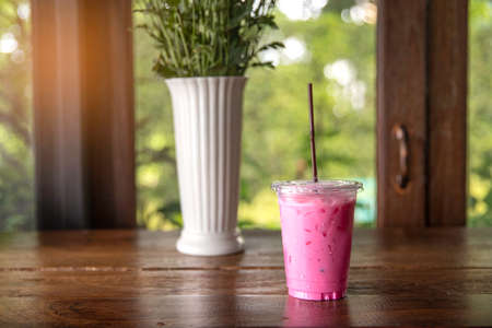 Strawberry smoothie, latte or milkshake in take away / to go cup at cafe on wooden table.の写真素材