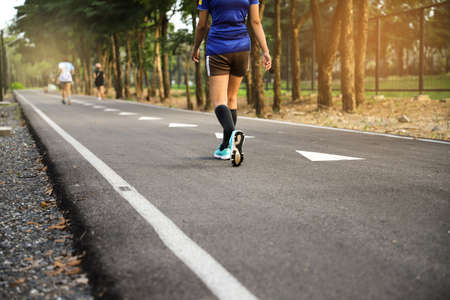 Fit woman walking in park during autumn timeの写真素材