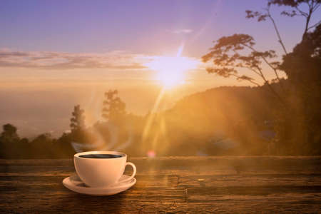 Close up coffee cup on wood table at sunset or sunrise background. nature conceptの写真素材