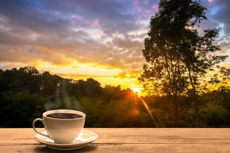 Close up coffee cup on wood table at sunset or sunrise background. nature conceptの写真素材