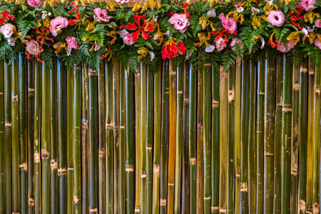 flowers with fern leaf decorate on wall of bamboo stick. Interior design concept.の写真素材