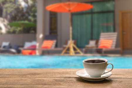 A cup of hot coffee  beside swimming pool. relaxation conceptの写真素材