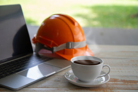 cup of coffee with laptop  and Safety Engineer Helmet on work space on  nature background.  relaxation conceptの写真素材
