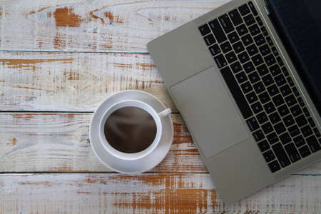 White coffee cup with laptop  on  wooden table. workspaceの写真素材