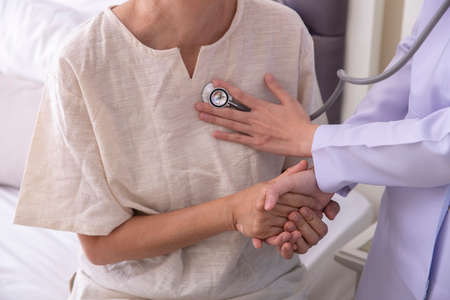 female medical doctor use stethoscope to listen examine check senior elderly patientâs heart and lung, health care conceptの写真素材