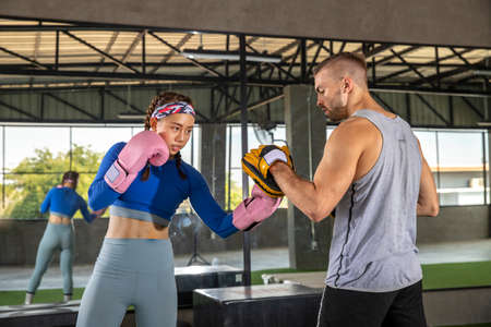 Young adult woman doing kickboxing training with her coach.. soprt conceptの写真素材