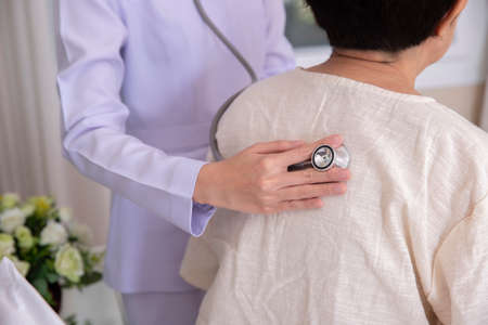 female medical doctor use stethoscope to listen examine check senior elderly patientâs heart and lung, health care conceptの写真素材