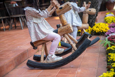 girls is riding swinging on a rocking chair toy horse outdoors background . imageの写真素材