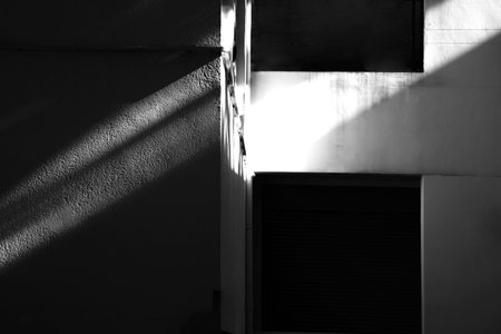 Abstract background of sunlight on concrete wall with shadows from the window - monochromeの写真素材