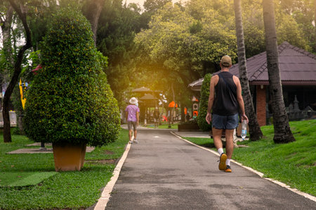 a man walking  on a path in a public park