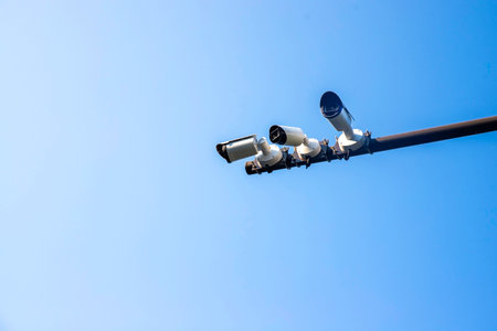 surround security cctv camera on grey steel post and blue sky with copy space, group of urban...