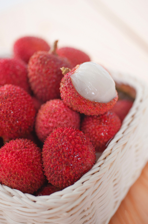 stack fresh lychee in basket on wood floorの写真素材
