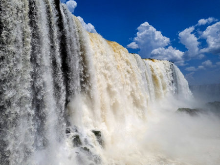 Close shot of the Iguazu Falls, at the Iguazu National Park, Brazil, clear stream water, blue sky, cloudsの写真素材