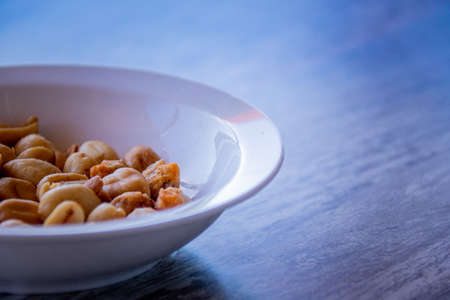 Bowl of peanuts on a woodden table