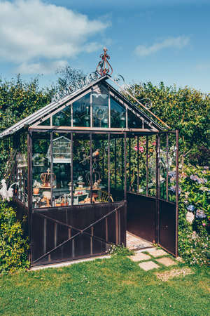 Decorative greenhouse in landscaped garden in summerの写真素材