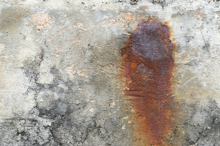 Old concrete wall texture background with dark red burn in the middle caused by rust nail