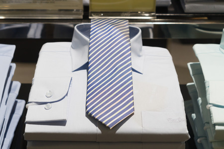 Tidy stacked luxurious shirts with beautiful ties, elegant shirts with beautiful ties