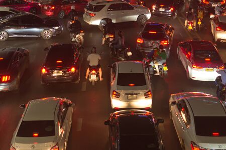Traffic jam causes severe congestion at night in downtown area. Cars get stuck in traffic jam at...